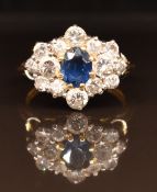 An 18ct gold ring set with an oval cut sapphire and round cut diamonds, 4.8g, size L