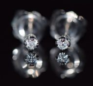 A pair of 9ct white gold earrings set with a diamond to each