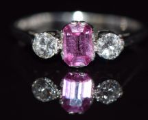 A platinum ring set with an emerald cut pink sapphire of approximately 0.7ct and two diamonds,