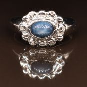 A 9ct white gold ring set with a star sapphire and diamonds, 5.3g, size M
