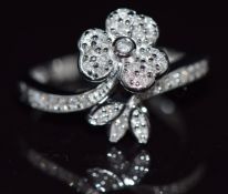 A 9k white gold ring set with diamonds in a floral setting, 4.2g, size N