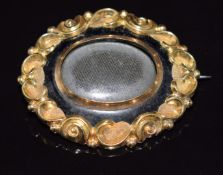 Victorian yellow metal brooch set with black enamel, with glass compartment to centre, 4.2 x 3.5cm