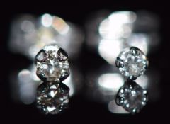 A pair of 9ct white gold earrings set with a diamond to each