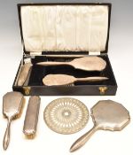 Two hallmarked silver mounted dressing table sets, both comprising hand mirror and two brushes,
