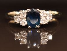 A 14k white gold ring set with an oval sapphire of approximately 1ct and six round brilliant cut
