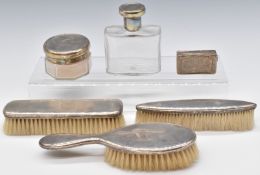 Silver mounted dressing table items comprising three brushes and two silver lidded glass items,