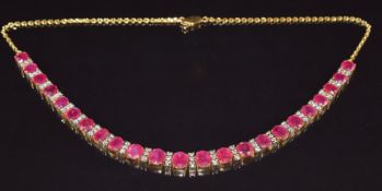 A yellow metal necklace set with twenty four oval cut rubies, the largest approximately 1.5ct, and
