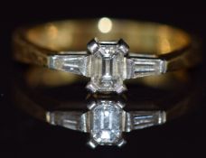 An 18ct gold ring set with an emerald cut diamond of approximately 0.3ct and two baguette cut