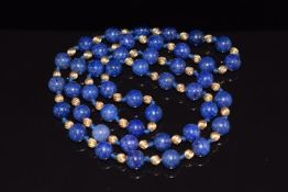 A necklace of lapis lazuli beads interspersed with textured gold beads, 74g, 76cm long