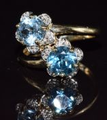 A 9k gold ring set with blue topaz and diamonds in a floral setting, 3.3g, size P