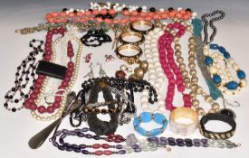 A collection of costume jewellery including bangles, two silver mounted items, beads, abalone