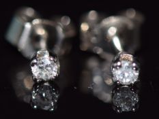 A pair of 18ct white gold earrings set with a round cut diamond to each