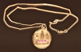 A 14k gold New York pendant set with synthetic rubies (5.3g) and 9k chain, 2.8g