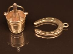 Two 9ct gold pendants/ charms, one a bottle of champagne in bucket and the other a horseshoe, 6.1g
