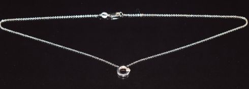 An 18ct white gold pendant set with a diamond on an 18ct white gold chain by Hearts of Fire, in