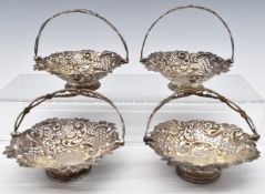 Set of four Victorian hallmarked silver swing handled baskets with pierced and embossed