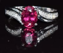 A 9k white gold ring set with an oval cut rubellite and diamonds, 2.4g, size P