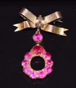 A 9ct gold bow brooch set with a garnet and seed pearl, with further drop pendant set with synthetic