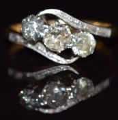 An 18ct gold ring set with three diamonds in a platinum twist setting, the largest diamond