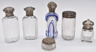 Six silver topped dressing table and scent bottles comprising five hallmarked silver lidded examples