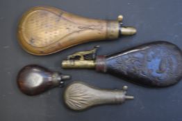 Four various powder and shot flasks comprising two copper examples with embossed decoration, a