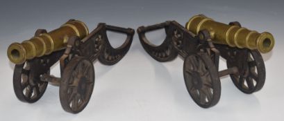 A pair of brass desk or fireside cannon with 11 inch multi-stage barrels, on cast iron carriages,
