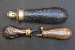 Three various powder flasks comprising one Sykes with leather covering, one with embossed decoration