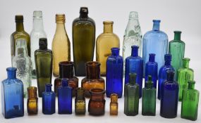 A collection of vintage glass bottles including two 19thC gin, poison, three Cardiff beer, malt,