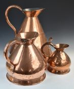 Three graduated copper measuring jugs including four gallon, tallest 47cm