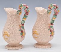 Clarice Cliff pair of pink Celtic Harvest pedestal jugs, H20cm
