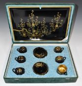 Black and gold lacquer coffee set comprising six cups and saucers with tray, in original fitted