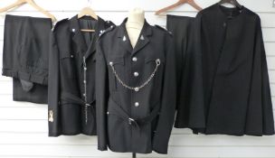 Two police uniforms with associated buttons and badges together with a police cape