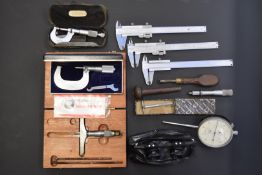 A collection of gun barrel measuring equipment including calipers, box depth measurer,