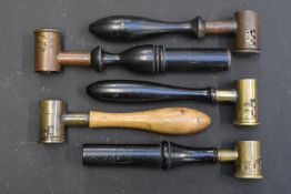 Five brass shot and powder measures, all with turned wooden handles.