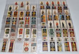 Approximately one hundred John Player's cigarette cards featuring military uniforms and cap badges