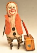 Schuco clockwork tinplate model clown with suitcase with painted facial features and felt