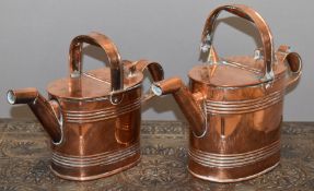 Two copper watering cans, height of tallest 25cm