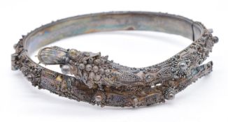 A late 19th/ early 20thC silver filigree bangle in the form of a dragon