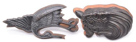 Two Japanese embossed metal plaques, one in the form of a crane the other a stylised tortoise.