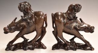 A pair of Chinese carved hardwood figures atop water buffalo, with inlaid wirework decoration,