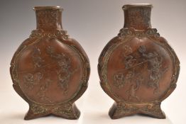 A pair of Japanese Meiji period bronze moon flasks decorated to both sides with performing circus