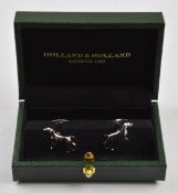 A pair of Holland & Holland stainless steel and gold plated cufflinks in the form of dogs, in fitted