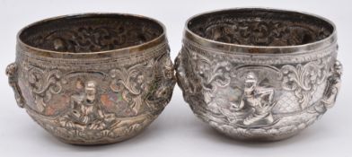 A pair of Indian / Burmese bowls with figural repoussé decoration and flower signature to bases,