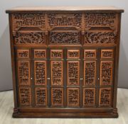 Chinese cabinet or cupboard decorated with heavily carved panels featuring figures, flowers and