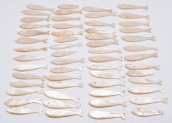Fifty six Chinese mother of pearl gaming counters formed as fish, length 5.5cm