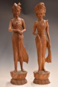 A pair of carved wooden Eastern female figures, one carrying a jambiya, largest 63cm tall.