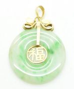A 14ct gold pendant set with a jadeite bi-disc and character decoration to the centre, 2.5cm