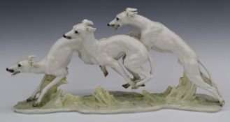 Heutschenreuther figure of three greyhounds racing, signed H Achtziger to base, W51 x H25cm
