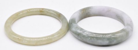 Two Chinese green and mottled green jade bangles, largest diameter 7.2cm