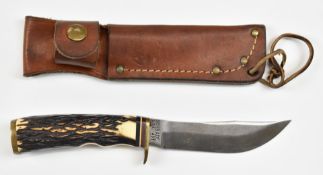 Schrade 497 hunting knife with 11cm blade and leather sheath. PLEASE NOTE ALL BLADED ITEMS ARE